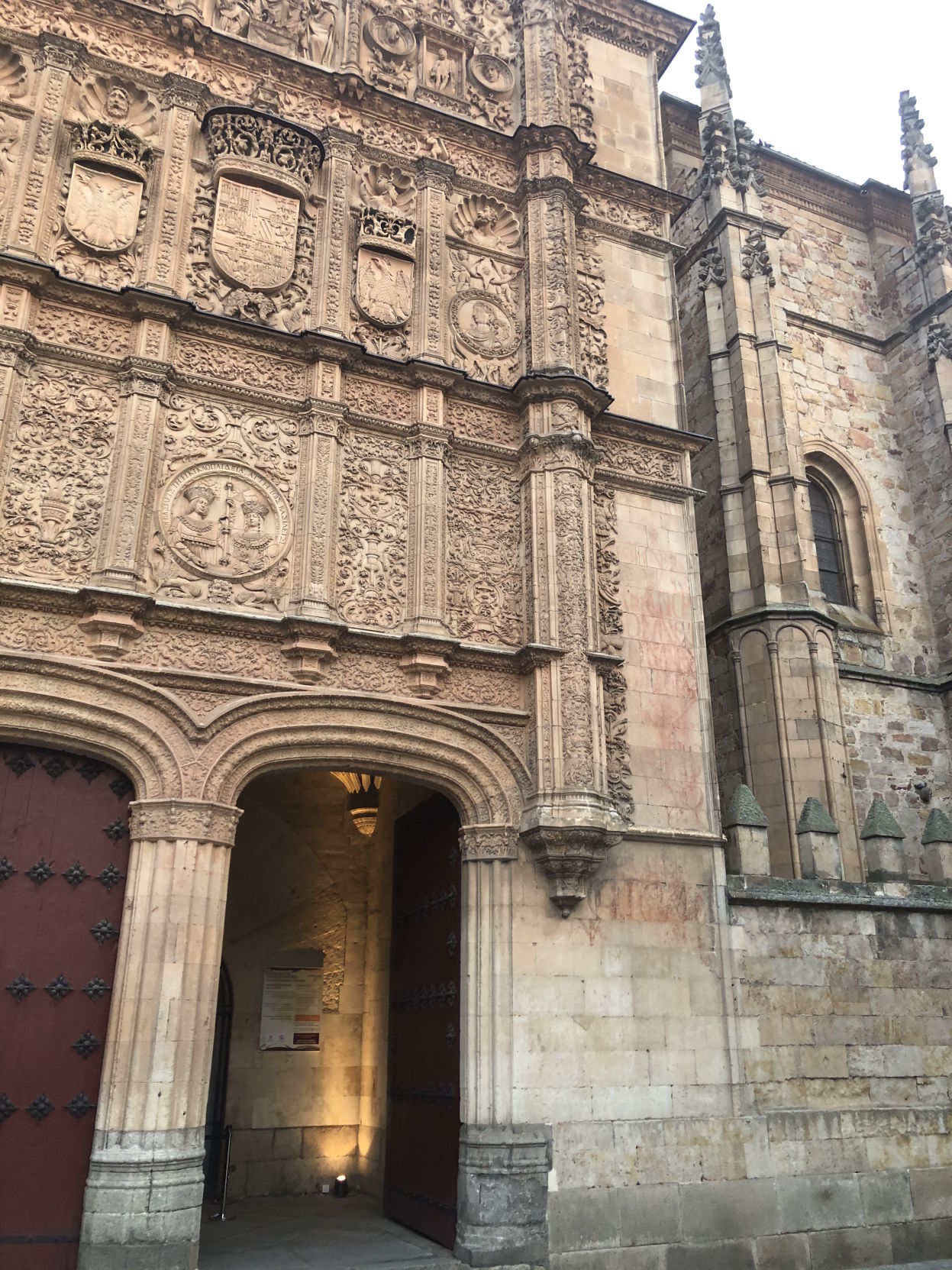 The facade of the University of Salamanca has two archways below ornate relief sculptures in the exterior walls
